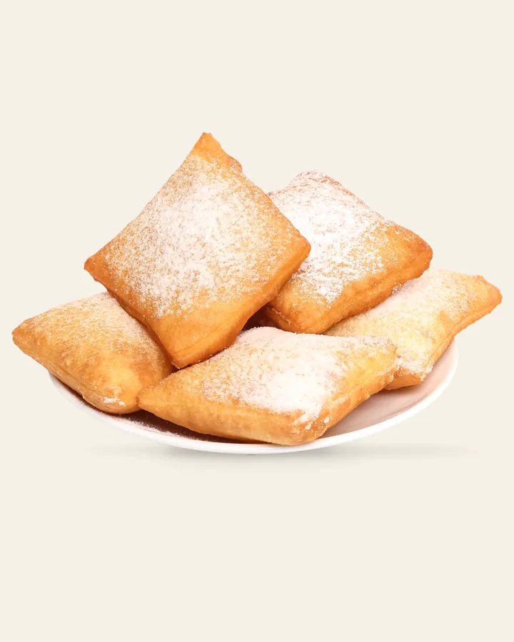 A plate of ViLand beignets dusted with powdered sugar.