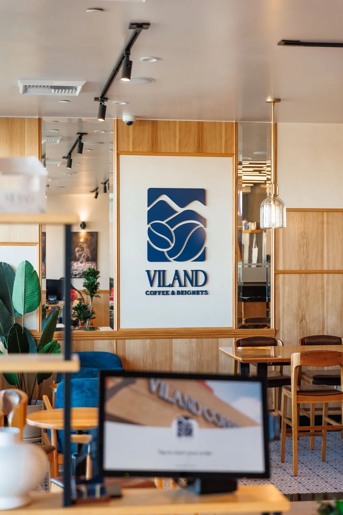 Wood seating and the ViLand wall sign inside the café.